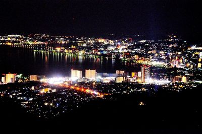 Illuminated city against sky at night