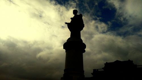 Low angle view of silhouette statue against sky