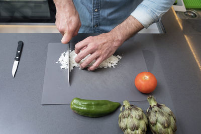 Midsection of man preparing food on cutting board