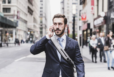 Usa, new york city, businessman in manhattan on cell phone