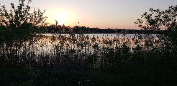 Scenic view of lake against sky at sunset