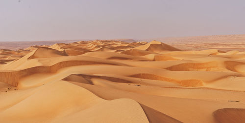 Sand dunes in desert against sky