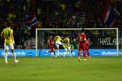 Group of people playing soccer on field