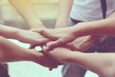 Cropped image of colleagues stacking hands