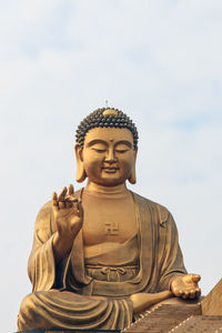 Close-up of buddha statue at fo guang shan against sky