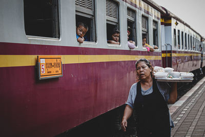 Portrait of young man standing against train