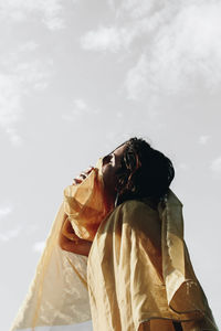 Low angle view of woman standing against sky