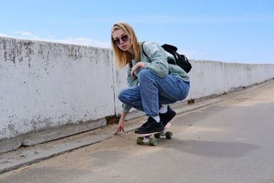 Full length of young woman walking on footpath
