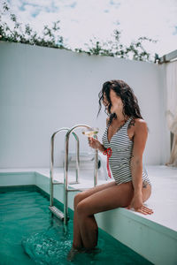 Woman sitting in swimming pool