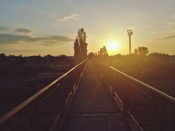 Railroad tracks against sky during sunset