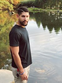 Portrait of young man standing at lake