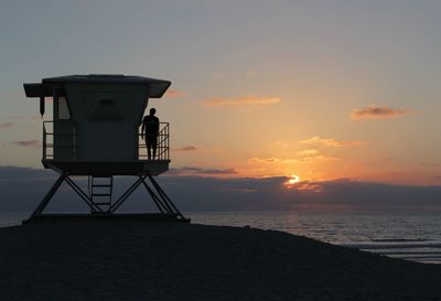 Silhouette of lighthouse at sunset