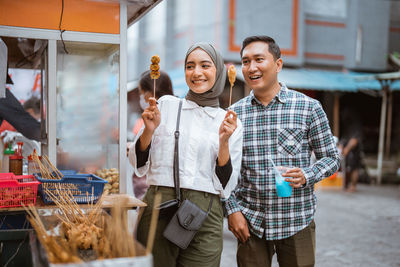 Portrait of smiling couple standing in city