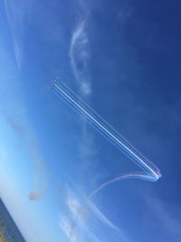 Low angle view of airplane flying against blue sky