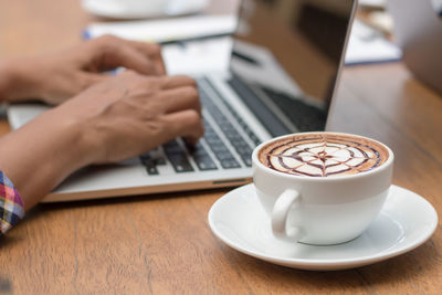 Midsection of coffee cup on table