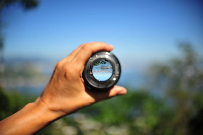 Close-up of hand holding camera lens