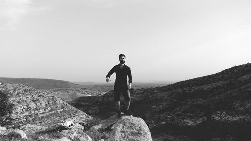 Full length of man standing on cliff against sky