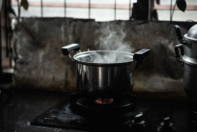 Close-up of steam emitting from bowl on gas at home