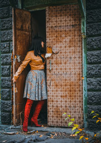 Woman standing at door of abandoned house