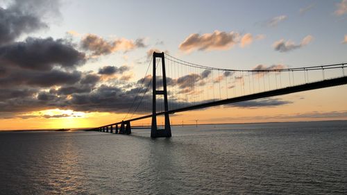 Bridge over sea against sky during sunset