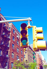 Low angle view of illuminated street light against blue sky