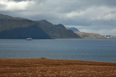 Scenic view of sea and mountains against sky