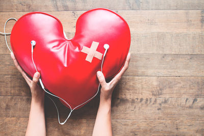 Midsection of woman holding heart shape with hands