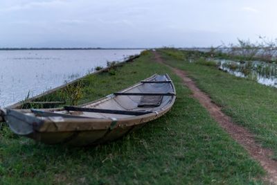 Boat moored on land against sky