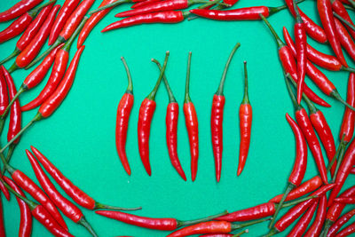 High angle view of red chili peppers on blue background