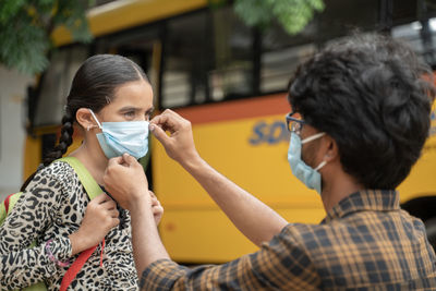 Man holding mask of girl