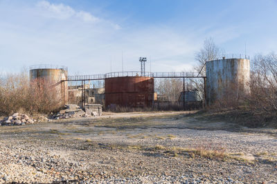 Abandoned factory on field against sky