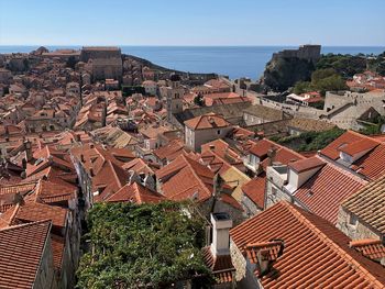 High angle view of townscape by sea against sky