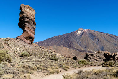 Scenic view of rocky mountains against clear blue sky