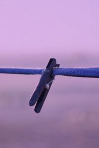 Low angle view of crane on rope against sky