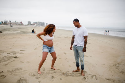 Mixed race couple goofing around on beach