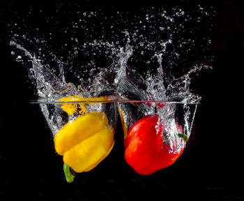 Close-up of fruits on water against black background