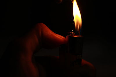 Close-up of hand holding burning candle