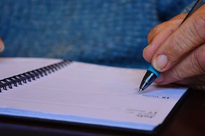 Close-up of person writing in diary