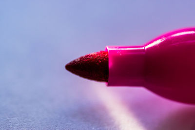 Close-up of pink bottle on table against blue background