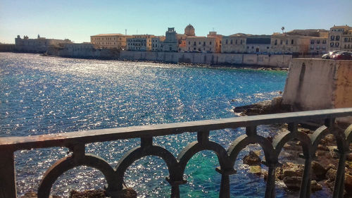 View of buildings by sea against sky