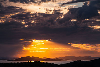 Low angle view of silhouette mountain against dramatic sky, murter, croatia