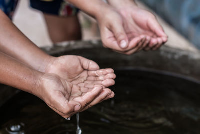 Cropped hand taking water from container