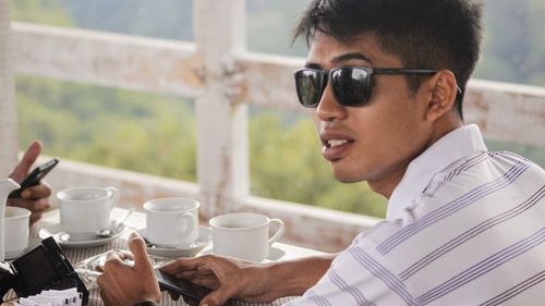 Portrait of young man holding coffee cup