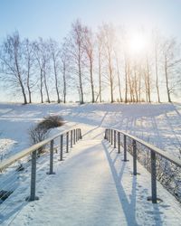 Snow covered field against sky during winter