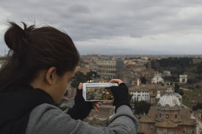Close-up of woman photographing cityscape