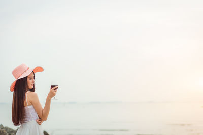 Woman standing on beach against clear sky