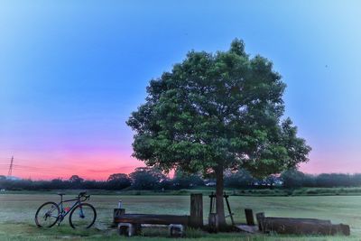 Bicycle on landscape against clear sky