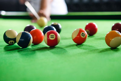 Midsection of man playing pool at club