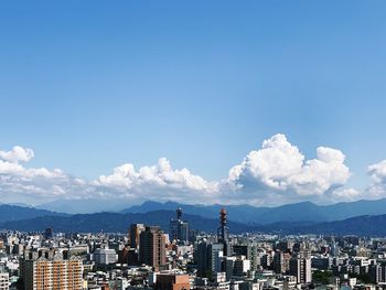Buildings in city against cloudy sky
