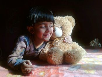 Girl with teddy bear at home